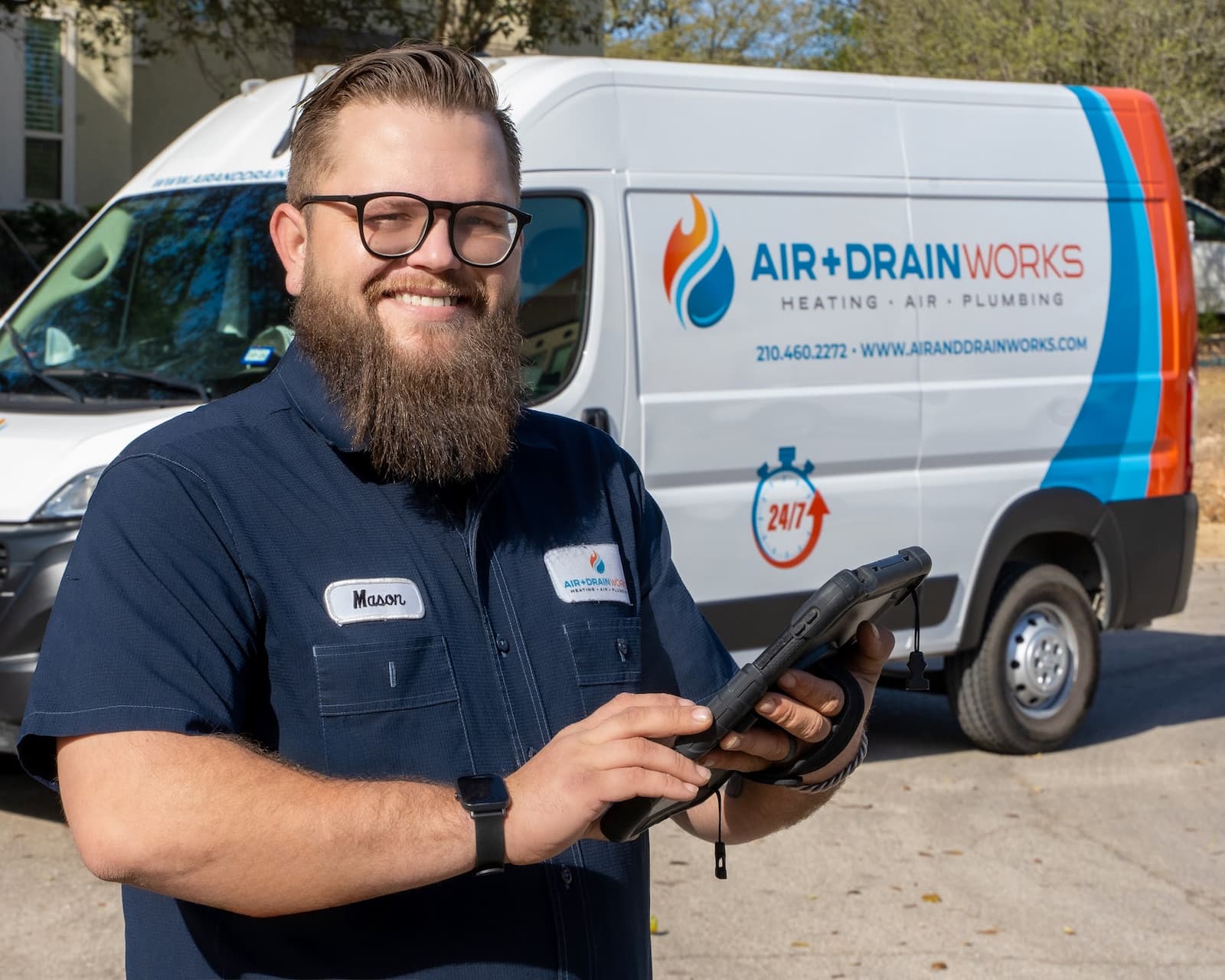 Mason, Air & Drain Works HVAC technician, standing in front of branded service van in San Antonio